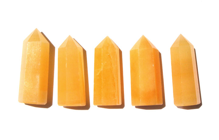 オレンジアラゴナイト 六角柱（癒し 対人運 人気運 六角ポイント 加工品 置物 置き物）を日光に当てて並べて撮影