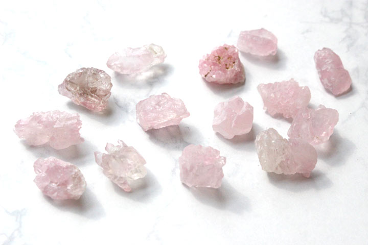 ローズクォーツ　結晶原石（天然石 パワーストーン お守り 恋愛運 癒し 紅水晶）を白い背景に置いて撮影